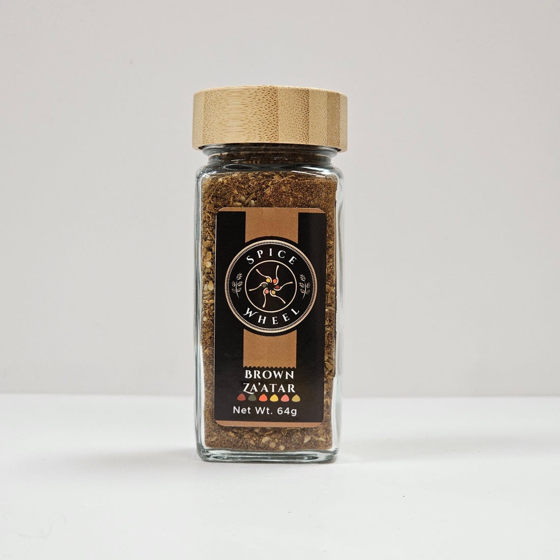 Glass jar of Spice Wheel Brown Za’atar with a label, containing a blend of herbs and spices for culinary use.