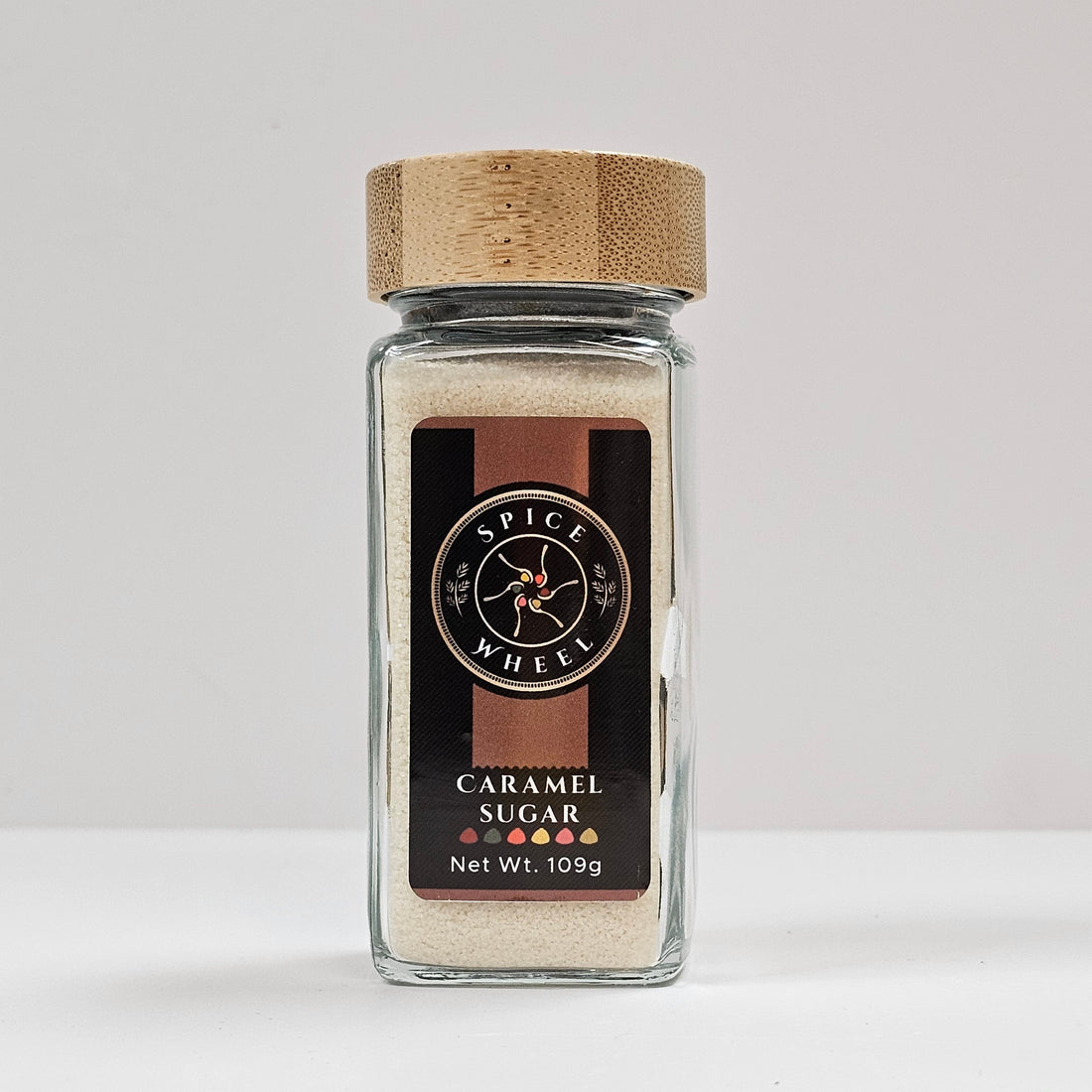 Glass jar of caramel sugar from Spice Wheel, showcasing the smooth caramel-colored sugar inside.