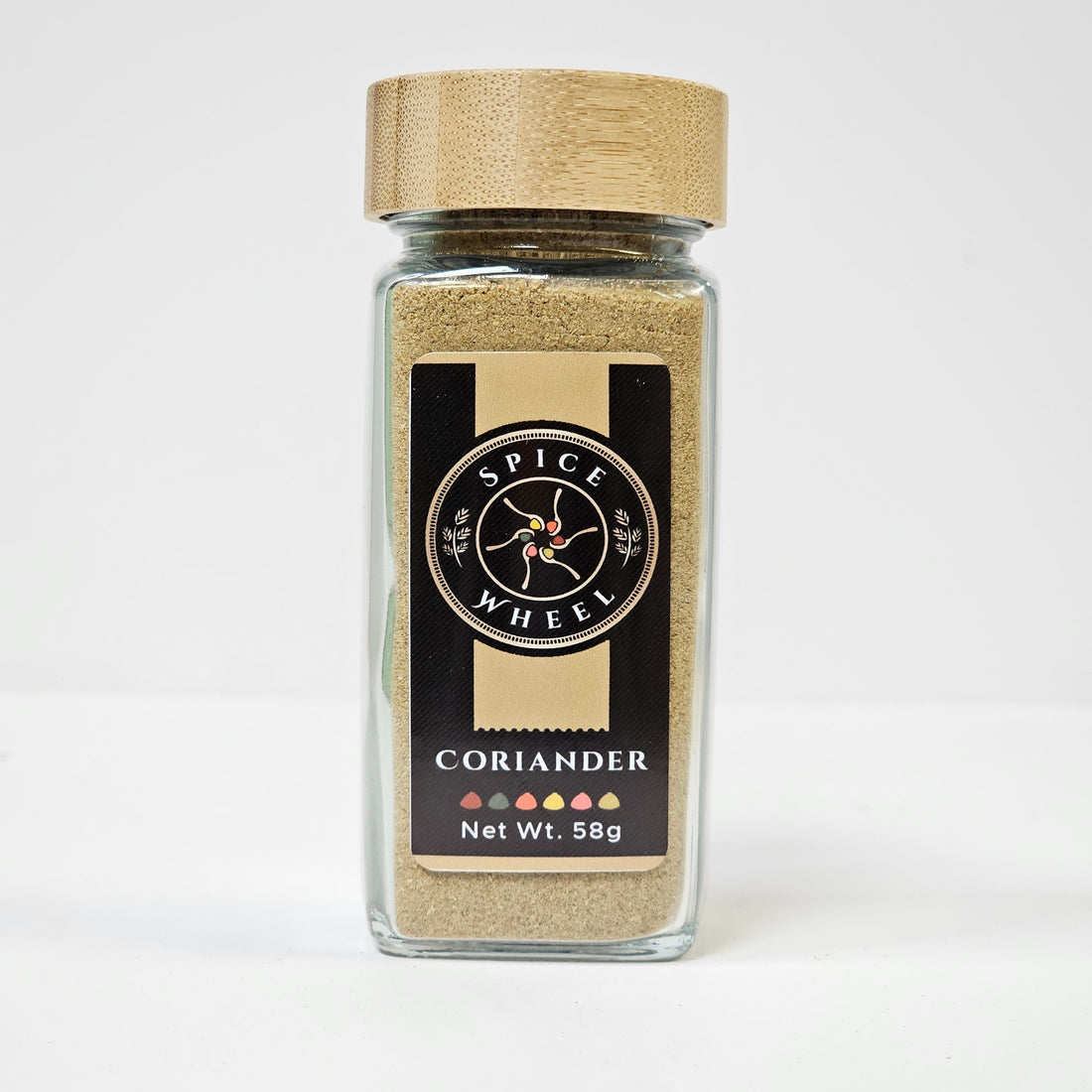 Glass jar of Spice Wheel coriander powder, showing the finely ground green herb inside the clear container.