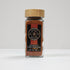 Glass jar of Spice Wheel Guajillo Powder with red chili powder inside, labeled container on a white background.