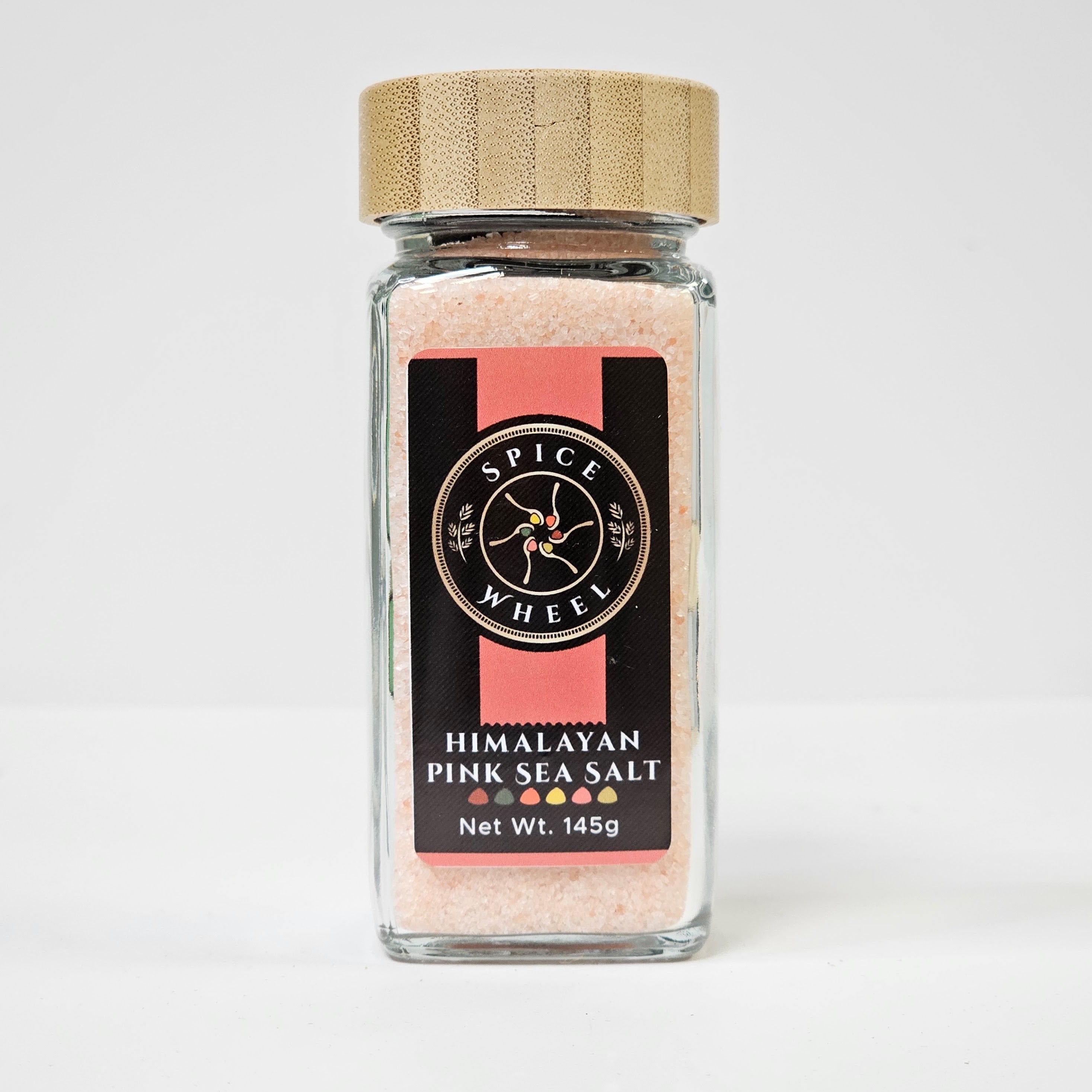 Himalayan pink sea salt in a clear glass jar, showcasing the coarse pink crystals, from Spice Wheel.