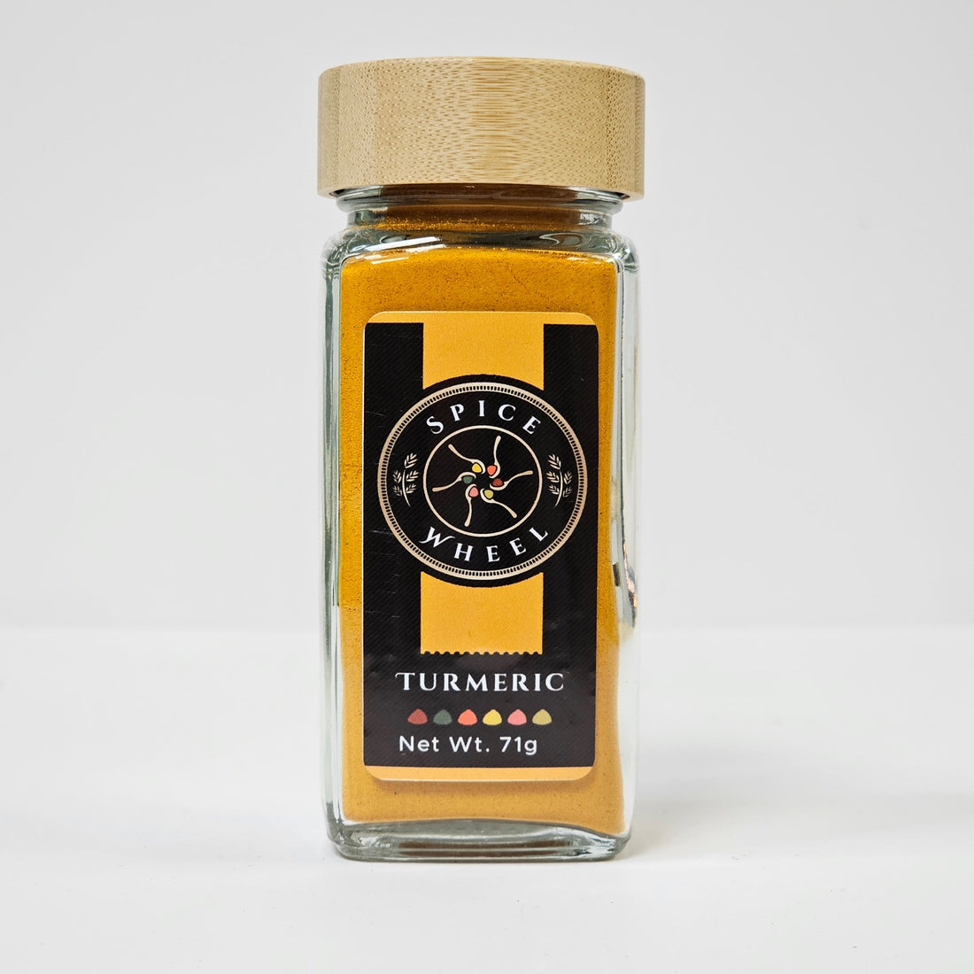 Glass jar of Spice Wheel turmeric powder with a bright yellow color, labeled and sealed for fresh use.