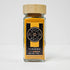 Glass jar of Spice Wheel turmeric powder with a bright yellow color, labeled and sealed for fresh use.