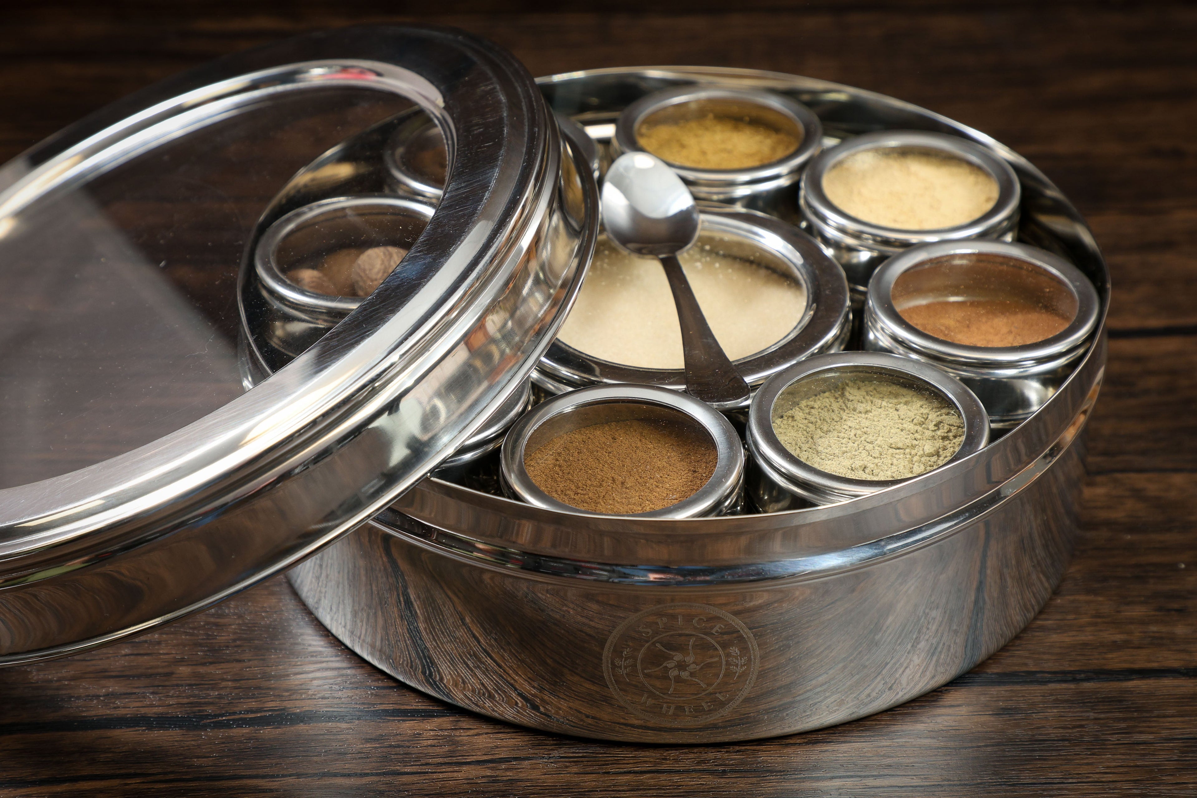 Close-up of a Spice Wheel baking spice wheel with lid, showcasing various baking spices arranged in a circular pattern.