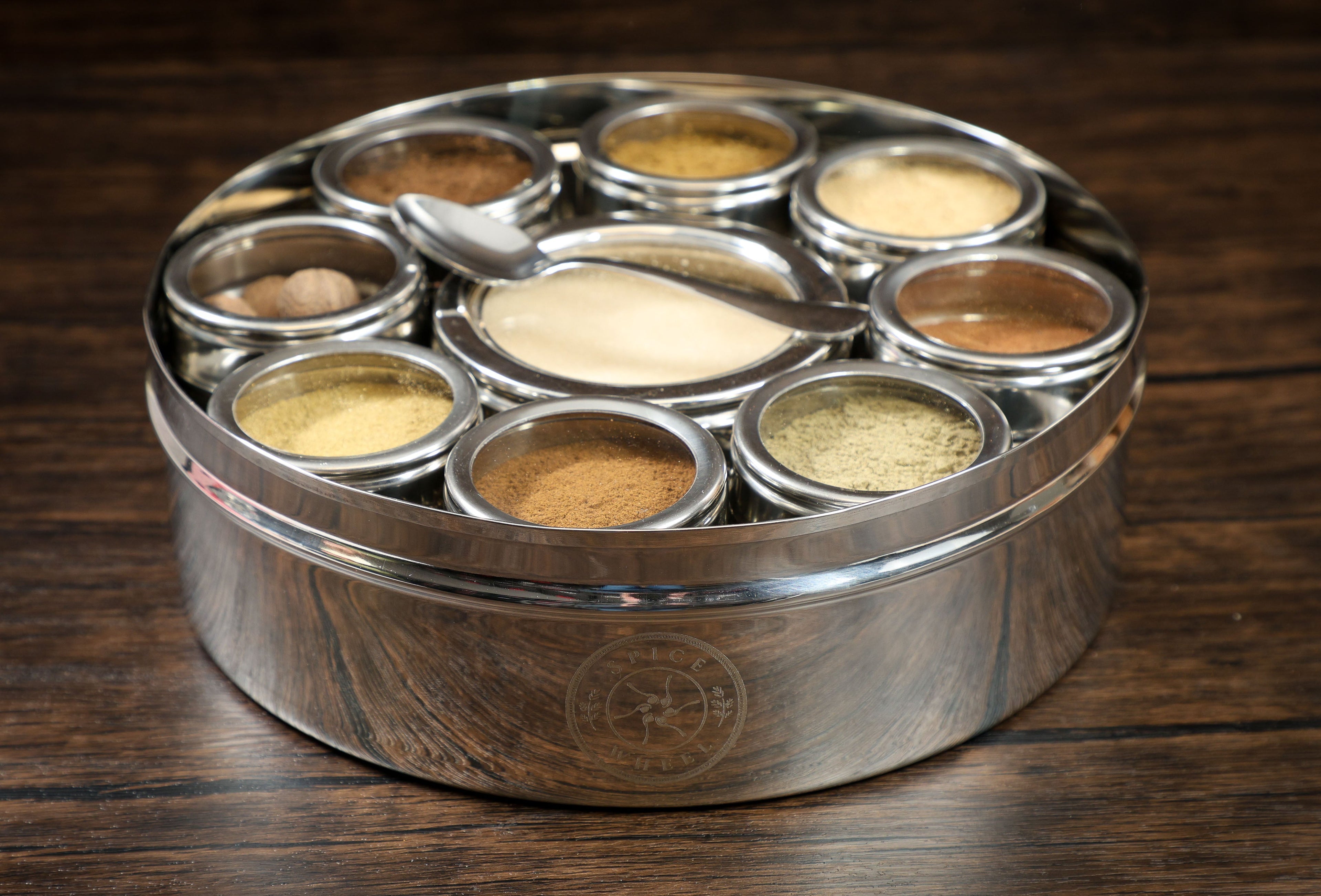 Close-up of a spice wheel used for baking, showcasing colorful sections with various baking spices on a white background.