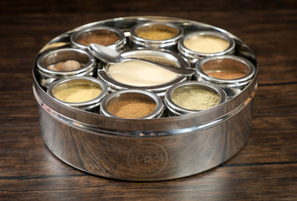 Close-up of a spice wheel used for baking, showcasing colorful sections with various baking spices on a white background.