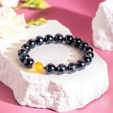 Deep healing bracelet featuring Arfvedsonite stones by Conscious Items, showcasing polished, natural gemstone beads on an elastic band.
