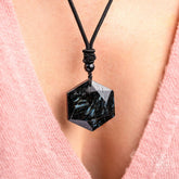 Deep healing Arfvedsonite necklace by Conscious Items featuring a polished pendant on a black cord.