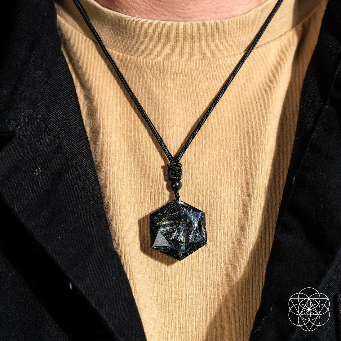 Deep healing Arfvedsonite pendant necklace by Conscious Items featuring a polished, dark gemstone pendant on a cord.
