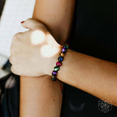 Handcrafted Bracelet of Resolve by Conscious Items featuring a woven design and symbolic charms on a neutral background.