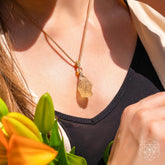 Libyan Desert Glass pendant necklace by Conscious Items featuring a polished, golden-yellow glass relic with intricate details.