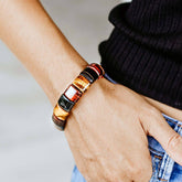 Close-up of the Conscious Items The Determination Bracelet featuring a sleek design and adjustable strap on a neutral background.