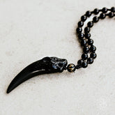 Black obsidian wolf pendant necklace by Conscious Items, featuring a detailed wolf design on a sleek chain.