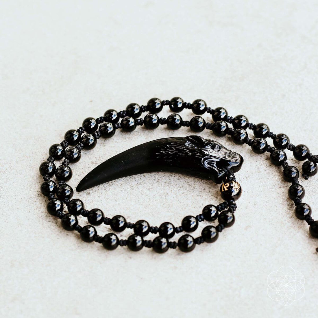 Dark obsidian wolf pendant necklace from Conscious Items featuring a detailed wolf design on a black cord.
