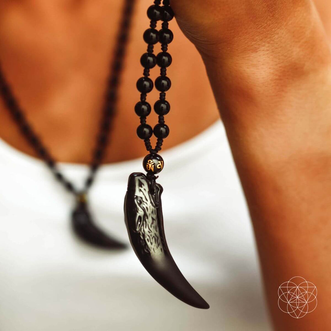Black obsidian wolf pendant necklace from Conscious Items featuring a detailed wolf design on a sleek chain.