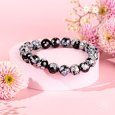Snowflake Obsidian bracelet by Conscious Items featuring black and white patterned beads on a stretchy cord.