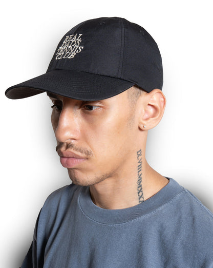 Black Real Dads Tennis Club cap with curved brim and adjustable strap, featuring embroidered logo on front.