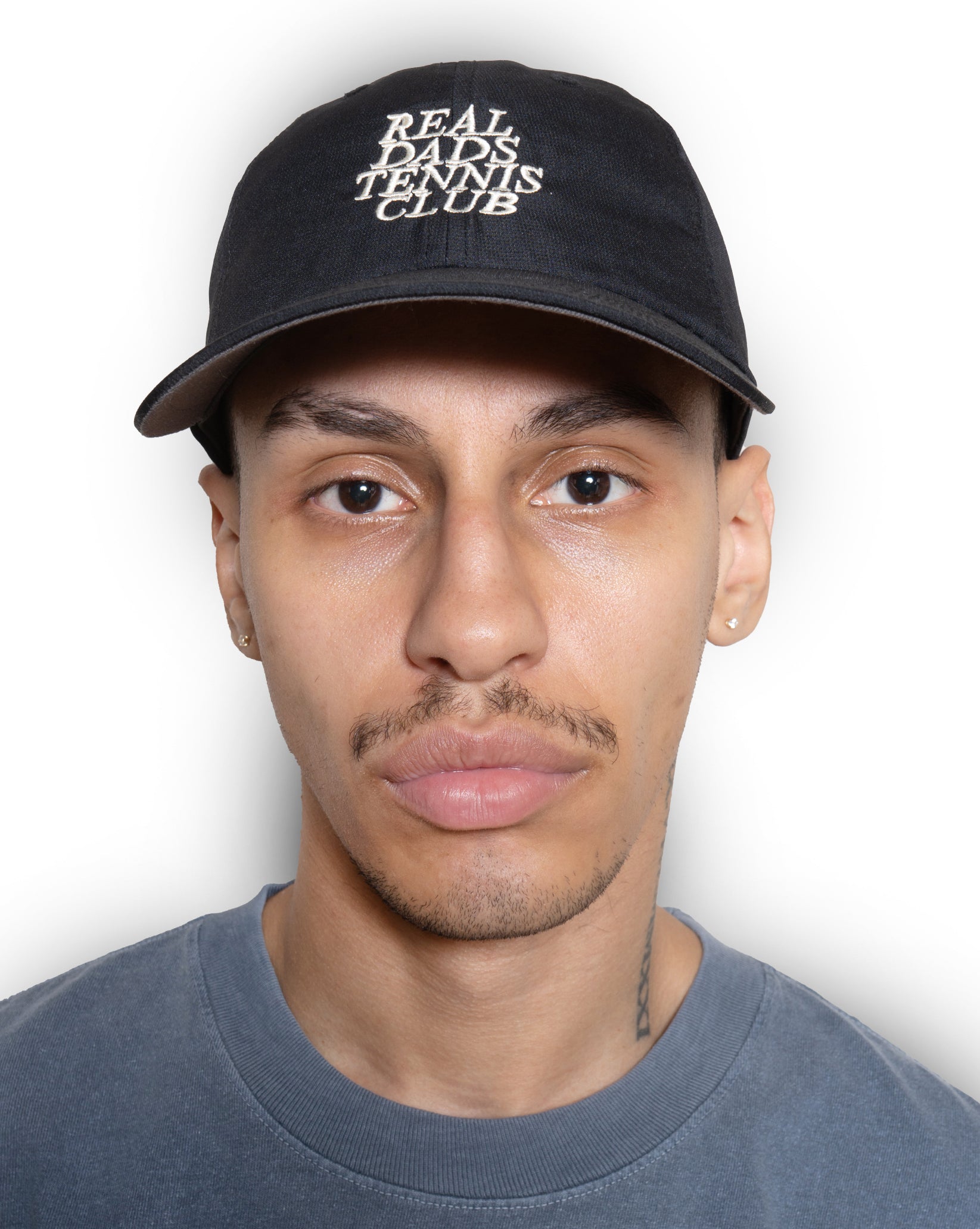 Black Real Dads Tennis Club Cap with adjustable strap and embroidered logo, stylish headwear for sports and casual wear.