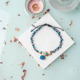 Silver triple crystal anklet of positivity with sparkling beads, featuring delicate chain links and vibrant crystal charms.