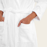 White Italic Ultraplush Australian Cotton unisex bathrobe draped on a hanger, showcasing soft, plush fabric and cozy design.