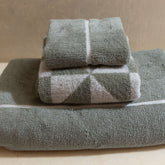 Set of soft, white Deia Australian Cotton Towels by Italic, displayed on a bed for home and bedroom use.